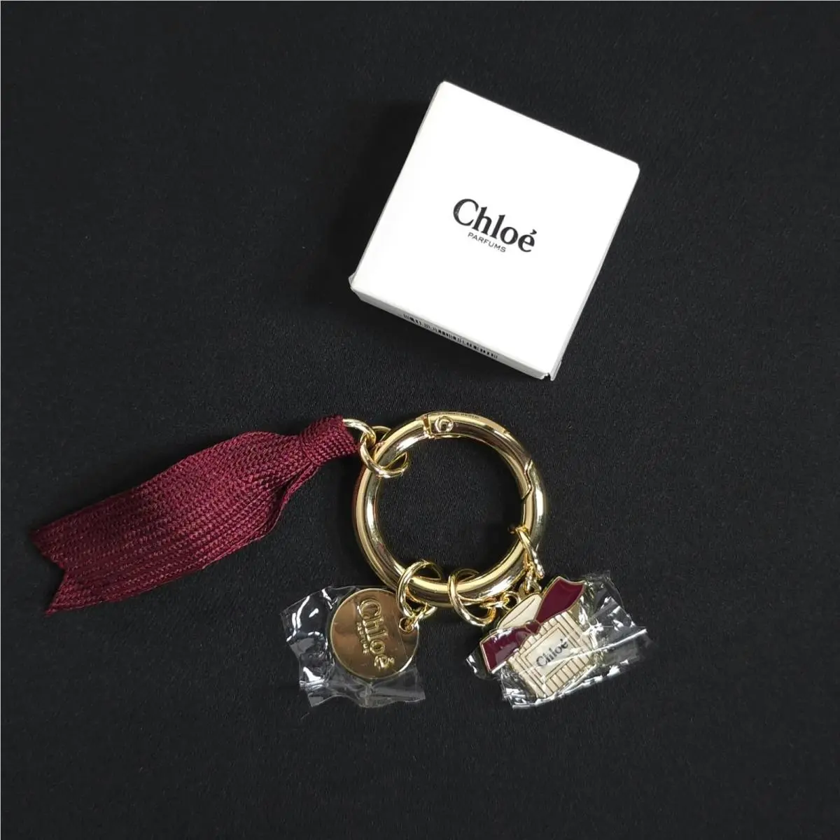 Chloe Women`s Keyring Bag Charm Gold Burgundy Ribbon Flower Perfume Bottle
